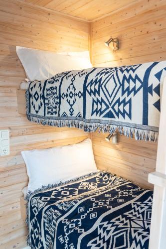 two beds in a room with wooden walls at Hausboot Baltic Goose in Burgtiefe auf Fehmarn 
