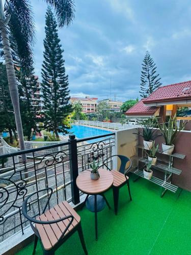a balcony with a table and chairs and a pool at POOLVIEW 2 bedrooms unit in Davao City