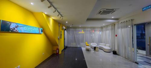 a lobby with a yellow wall and toilets in a building at Lemonade Hotel in Miri