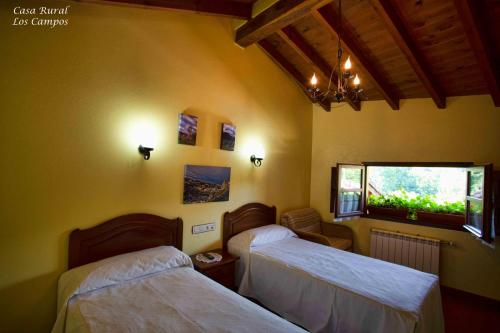 a room with two beds and a window at Casa Rural Los campos in Corao