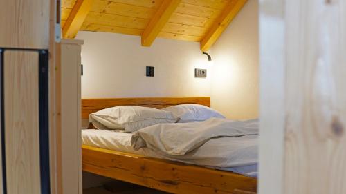 a bed with white sheets and pillows in a room at Boroviti Mountain House in Blidinje