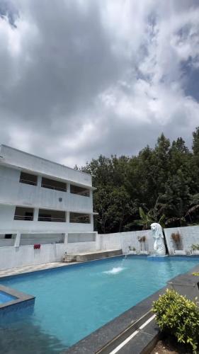 an empty swimming pool in front of a building at Mount Coco Resort Yercaud in Yercaud