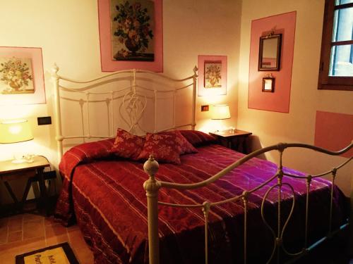 a bedroom with a bed with a red comforter at Il Nido Cortona in Cortona