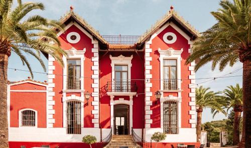 a red house with palm trees in front of it at DWO Finca Los Abetos in Córdoba