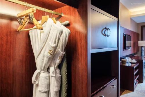a closet with white towels hanging on a wall at Dingyi Hotel in Heilinpu