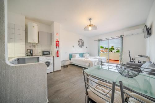 a kitchen and living room with a table and a couch at Bellavista Jardim By BeGuest in Albufeira