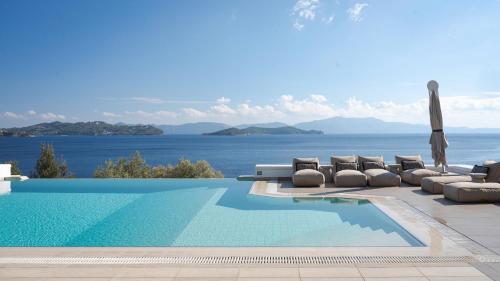 a pool with lounge chairs and a view of the ocean at Luxury Villas Skiathos in Skiathos