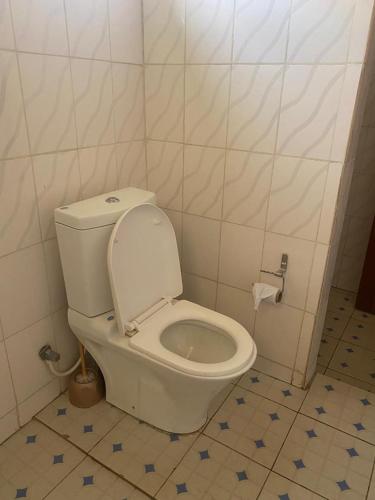 a bathroom with a toilet with the lid up at Welcome Inn Guest house in Kigali