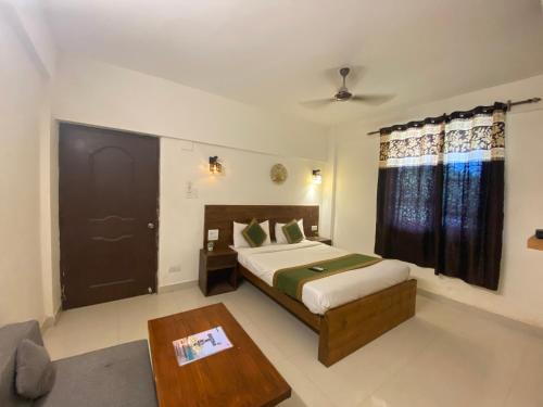 a bedroom with a bed and a coffee table at The Mamta Courtyard Anjuna in Anjuna