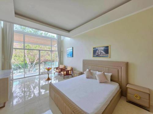 a bedroom with a bed and a large window at Ta Yai Beach Resort in Pattaya