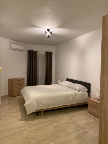 a bedroom with a large white bed in a room at Xagħra Lodge in Xagħra