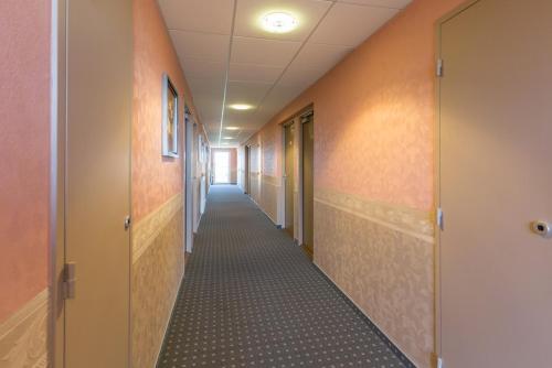 a hallway of an office building with a long corridor at Pressoir Hôtel in Saint-Calais
