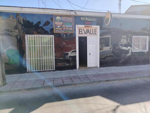 a building with a white door and a mural at El valle in Copiapó