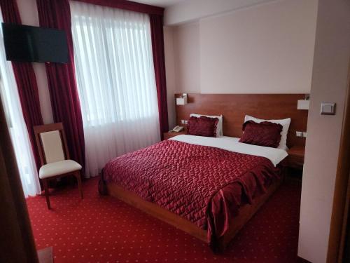 a hotel room with a large bed and a chair at Motel Aleksandar in Pojate