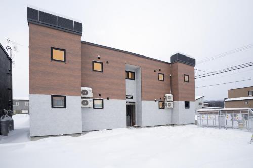a large brick building with windows on the side at Niseko Town Retreat AMBER in Kutchan