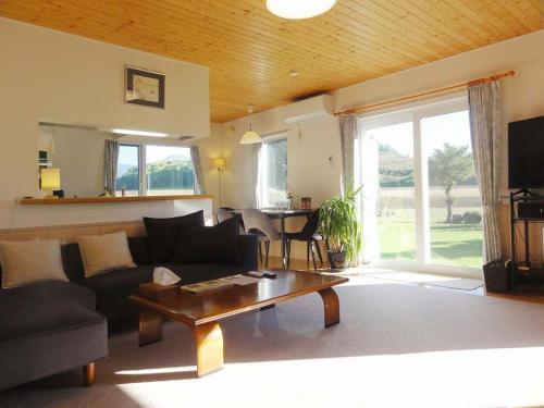 a living room with a couch and a table at Hillview cottage Sanfurano in Kami-furano