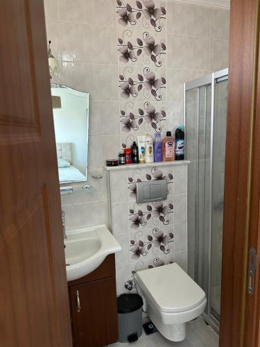 a bathroom with a sink and a toilet and a mirror at Eos in Çeşme