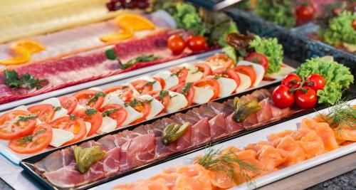 a display of different types of food on trays at PLAZA INN Schmöker-Hof in Norderstedt