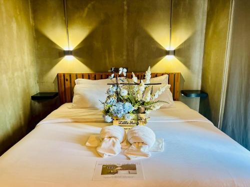 a bed with towels and a vase of flowers on it at Bangkok Phattanakan32 guest house in Bangkok