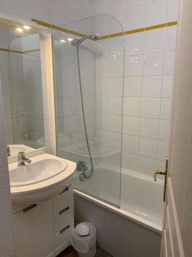 a white bathroom with a sink and a shower at Chalet des Evettes in Flumet