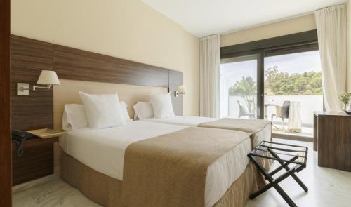 a hotel room with a large bed and a window at DWO Finca Los Abetos in Córdoba