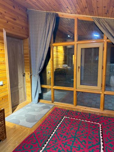 a room with a large window and a red rug at Ala-Archa Mountain House in Vorontsovskoye
