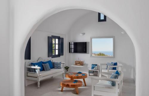 a white living room with a couch and a table at Finikia Memories Hotel in Oia