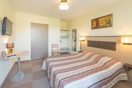 a hotel room with a bed and a desk at Pressoir Hôtel in Saint-Calais