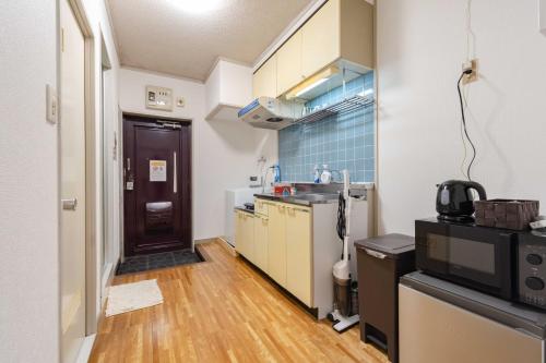 a small kitchen with a sink and a counter at Kasuga Good Place House in Kasugabaru