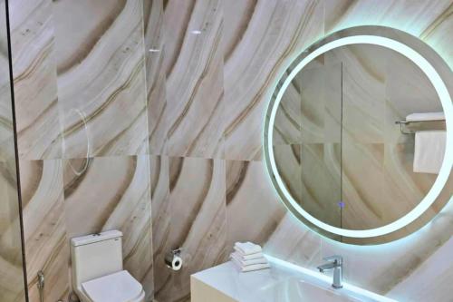 a bathroom with a mirror and a toilet and a sink at Ta Yai Beach Resort in Pattaya