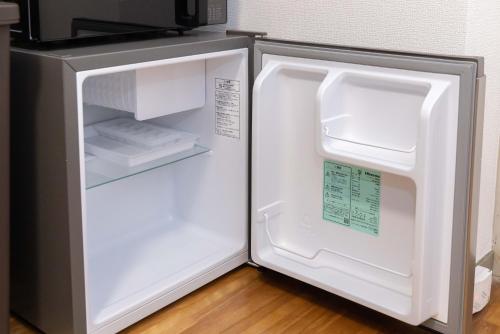 a refrigerator with its door open in a kitchen at Kasuga Good Place House in Kasugabaru