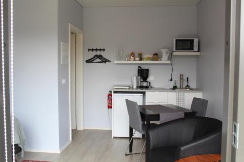 a small kitchen with a small table and a counter at Systrakot - Studio Apartments in Talknafjordur