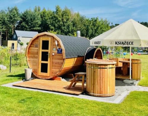 a small wooden boat with a table and an umbrella at Apartament Paula SPA Niechorze in Niechorze