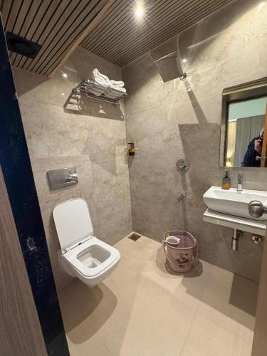 a bathroom with a toilet and a sink at Sahara Inn in Mumbai
