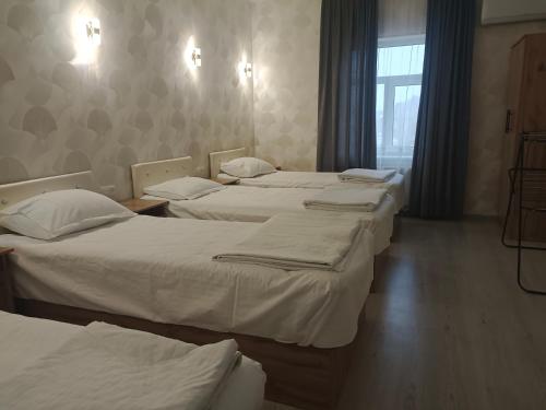 a group of three beds in a room at Bobur Guest House in Khiva