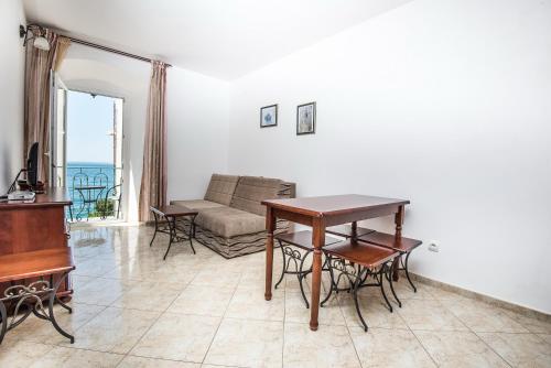a living room with a table and a couch at Apartments Obala Dragovic in Petrovac na Moru