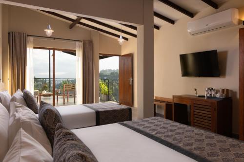 a hotel room with two beds and a television at Oak Ray Sky Terrace in Kandy