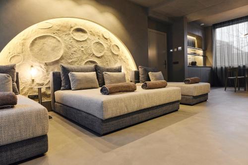 a living room with two couches in front of a wall at Guest House Valea Morilor in Chişinău