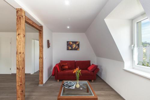 a living room with a red couch and a table at Ferienapartments Pirna in Pirna