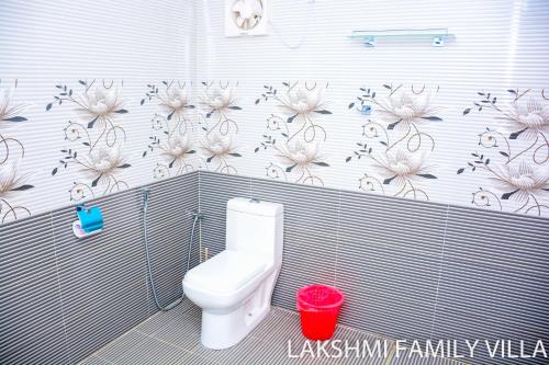 ネゴンボにあるLakshmi Family Villaのバスルーム(トイレ付)が備わります。壁に花が飾られています。