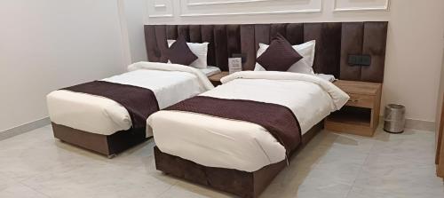 two beds sitting next to each other in a room at Hotel The Coal in Alīgarh