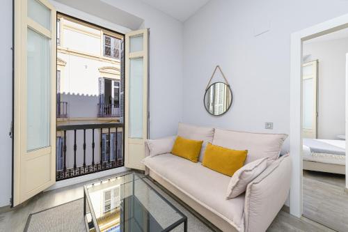 a living room with a couch and a glass table at Apartamentos Calle Larios in Málaga