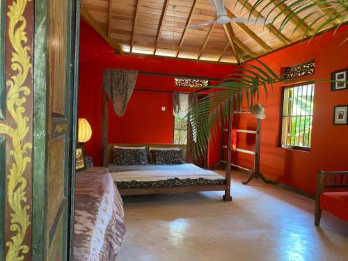 a bedroom with a bed in a red room at Dragon-Fly Home Hikka in Dodanduwa