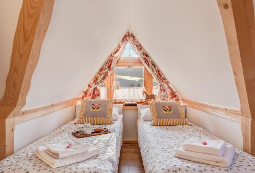 2 camas en una habitación con ventana en Apartamenty Tatra View Zakopane, en Zakopane