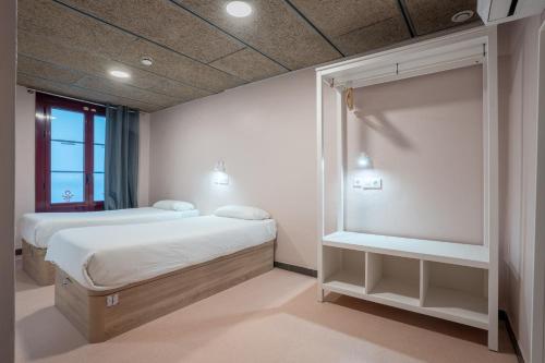 a bedroom with two beds and a window at Malacuna Barcelona in Barcelona