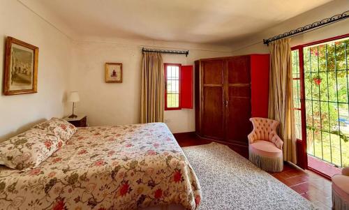 a bedroom with a bed and a large window at Hacienda Don Rodrigo in Alcalá de Guadaira