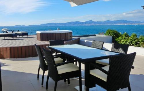a dining table and chairs on a patio with the ocean at Robert Christopher Börner in Badia Gran
