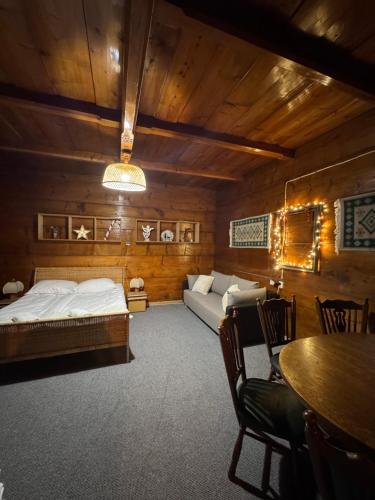 a living room with a bed and a couch at Przytulisko Dom na wyłączność in Biały Dunajec