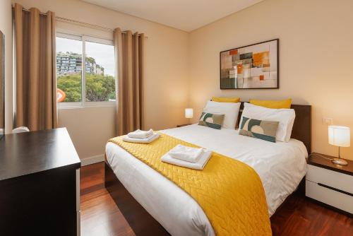 a bedroom with a large bed and a window at Premium Avenue Two Bedrooms Apt in Funchal