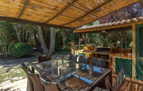 a patio with a table and chairs under a pergola at Casa Maria in Santa Maria del Camí